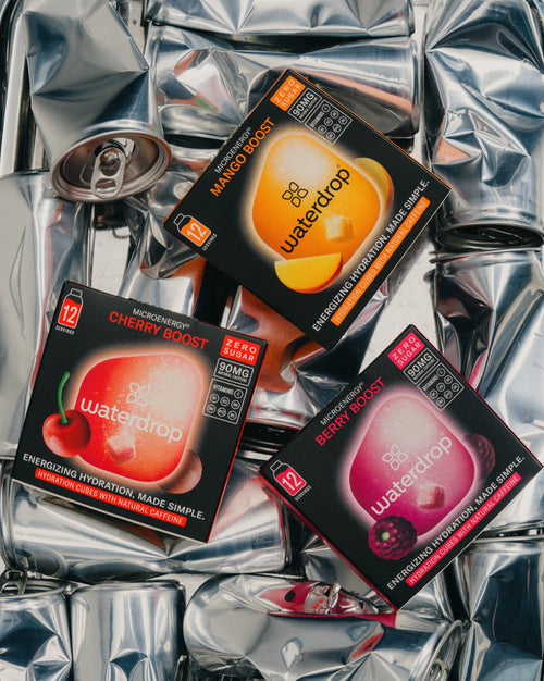 Confezione Doppia Microenergy BOOST tra lattine accartocciate.