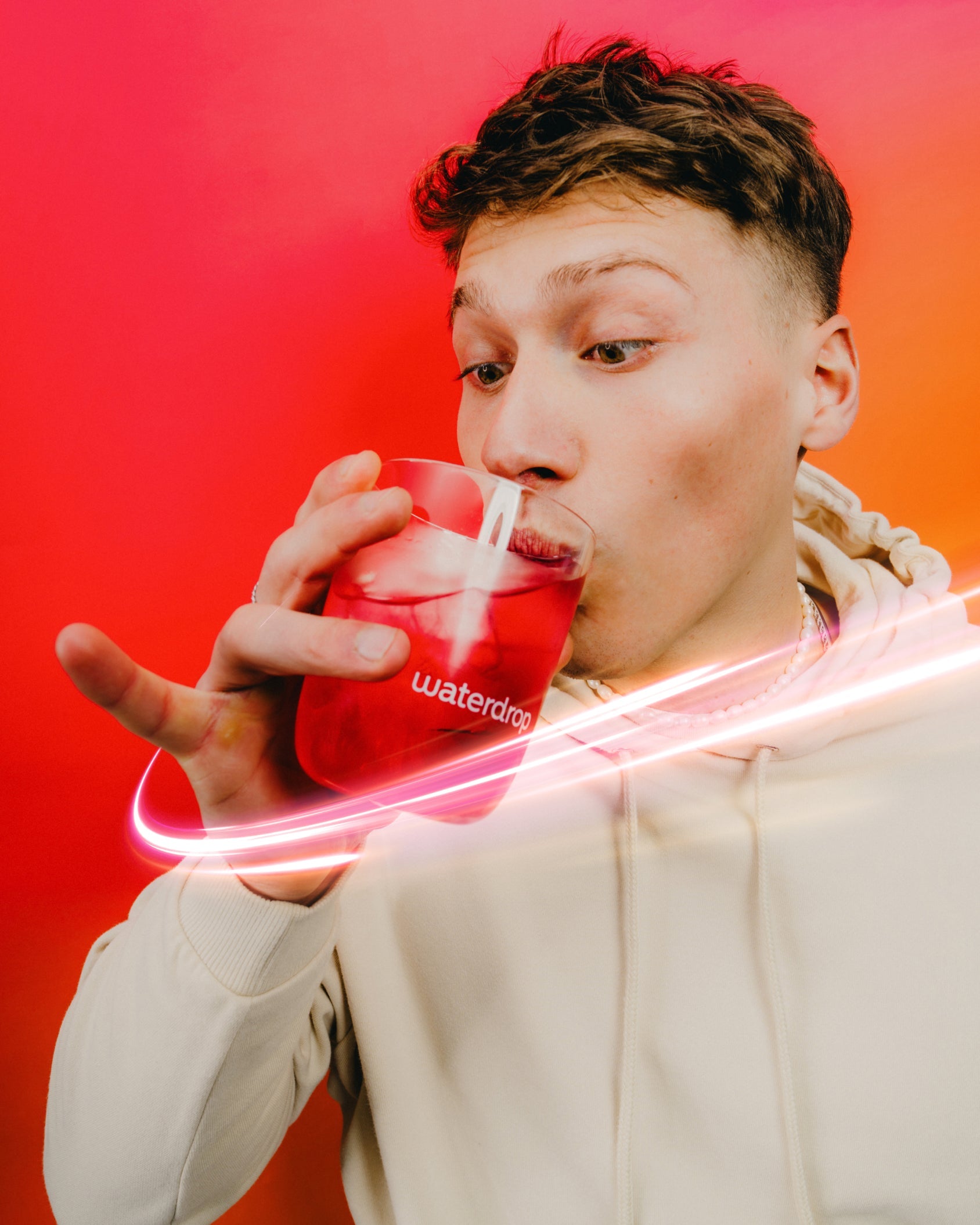 Persona beve Set Microenergy Booster di waterdrop® in bicchiere trasparente.