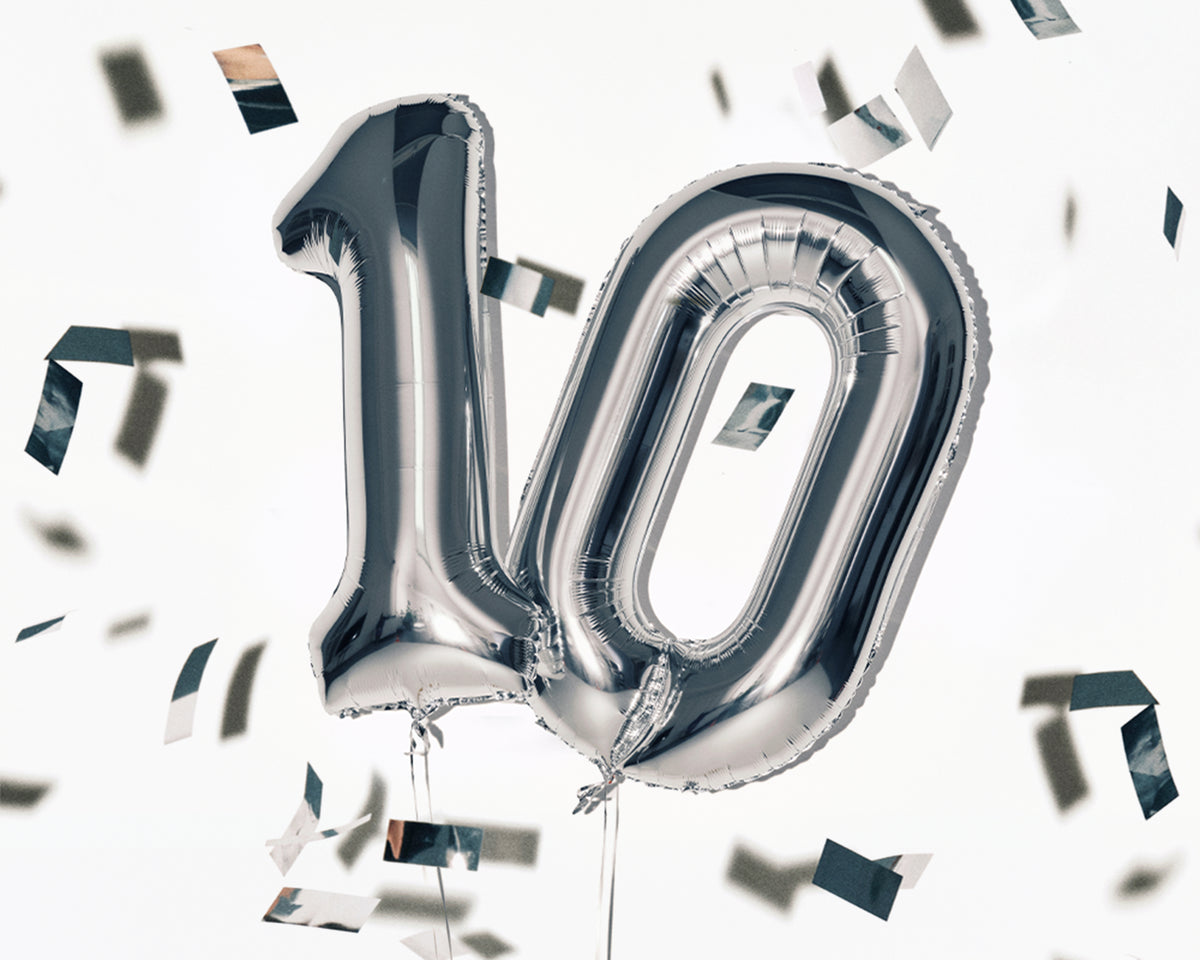 Palloncini in foil argentato a forma del numero 10 con coriandoli sparsi.