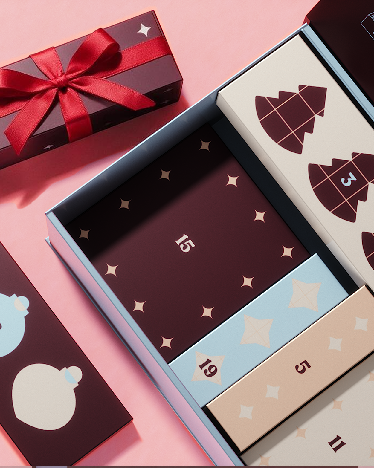 Calendario dell'Avvento con pannelli decorativi e una confezione regalo rossa su sfondo rosa.