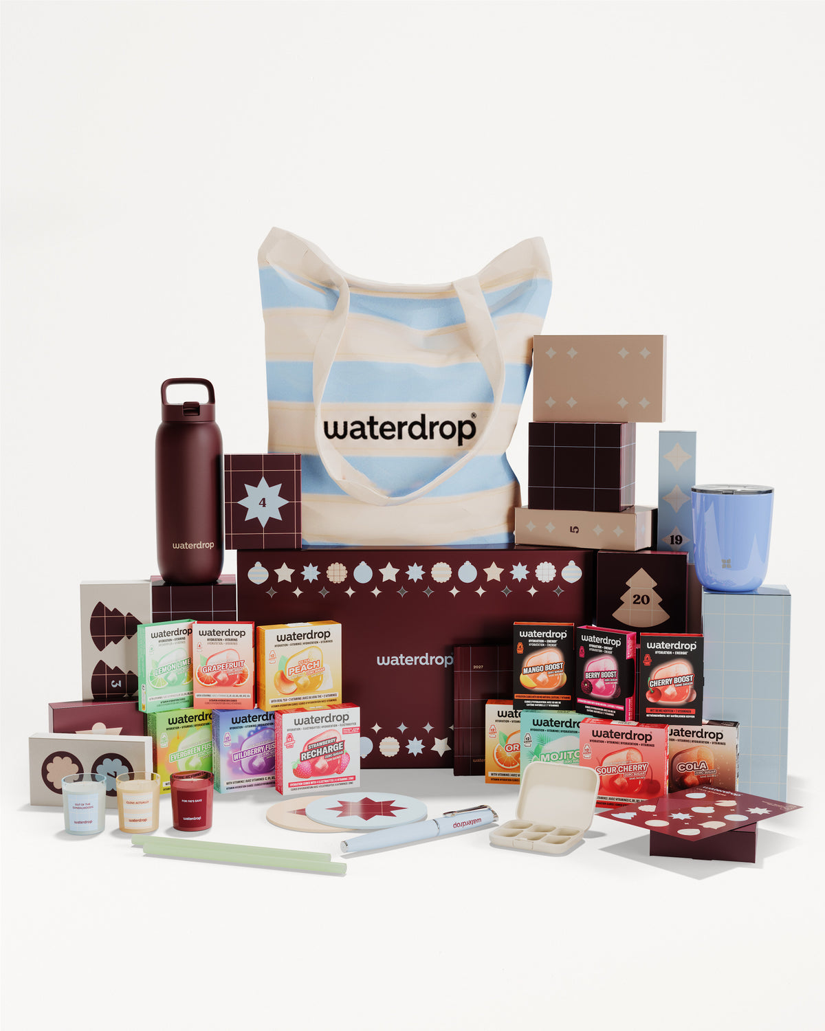 Set regalo con prodotti in scatole e contenitori vari, disposti intorno a una borsa a righe.