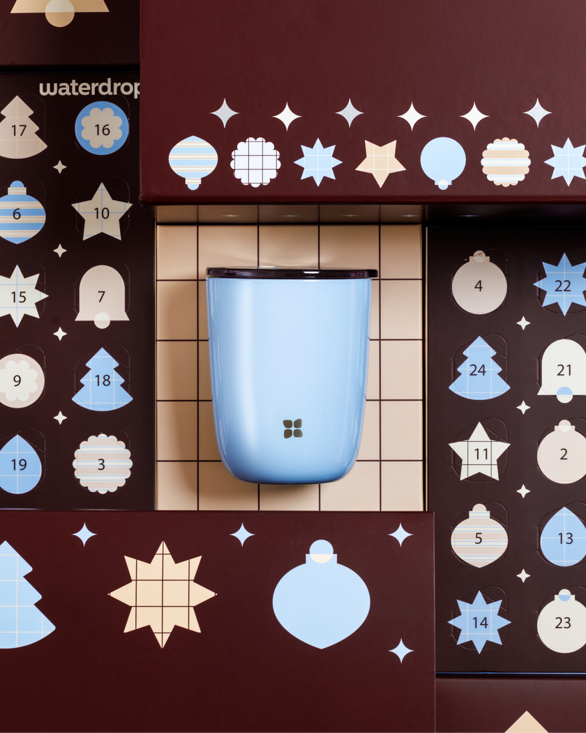 Contenitore arrotondato azzurro chiaro montato su un pannello in legno con decorazioni a buchi circolari e a forma di stelle.