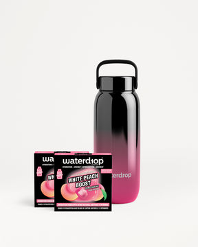Borraccia riutilizzabile con gradiente dal nero al rosa vicino a due confezioni Waterdrop.