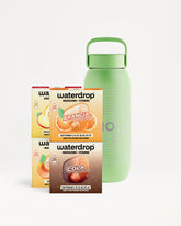 Confezioni Waterdrop per idratazione in scatole accanto a una bottiglia riutilizzabile verde.