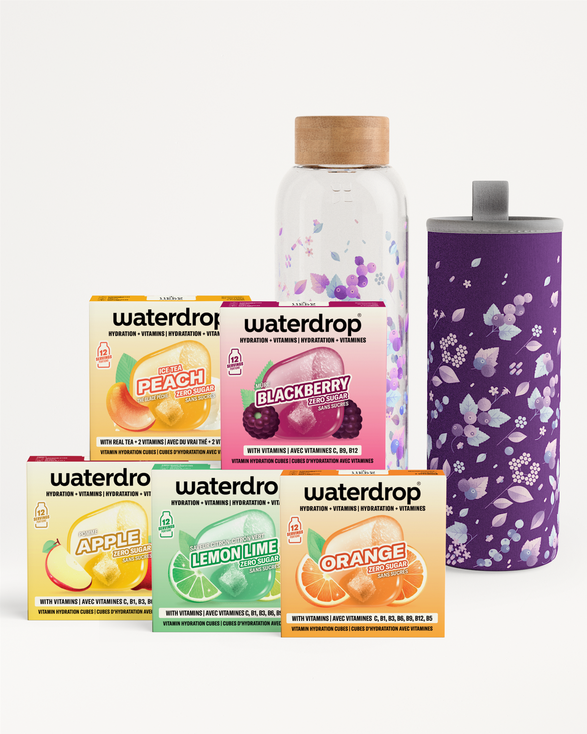 Scatola assortita di confezioni gusto bevanda in colori vivaci, una bottiglia di vetro con tappo e una tazza termica viola con motivo floreale.