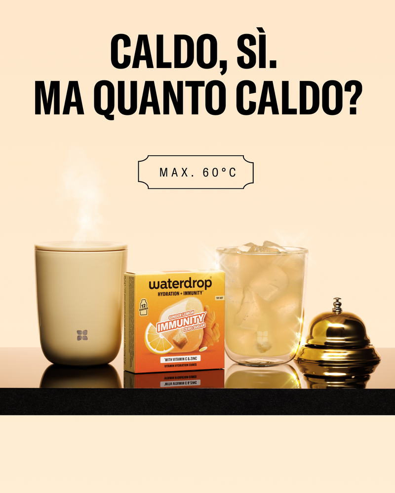 Tazza con vapore, prodotto Waterdrop immunità in scatola, bicchiere con ghiaccio e coperchio dorato su una mensola scura.