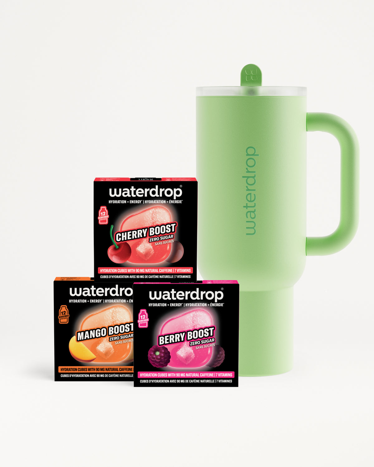 Tre scatole di booster di gusto in arancione, rosa e viola accanto a una tazza isolante verde chiaro con manico.