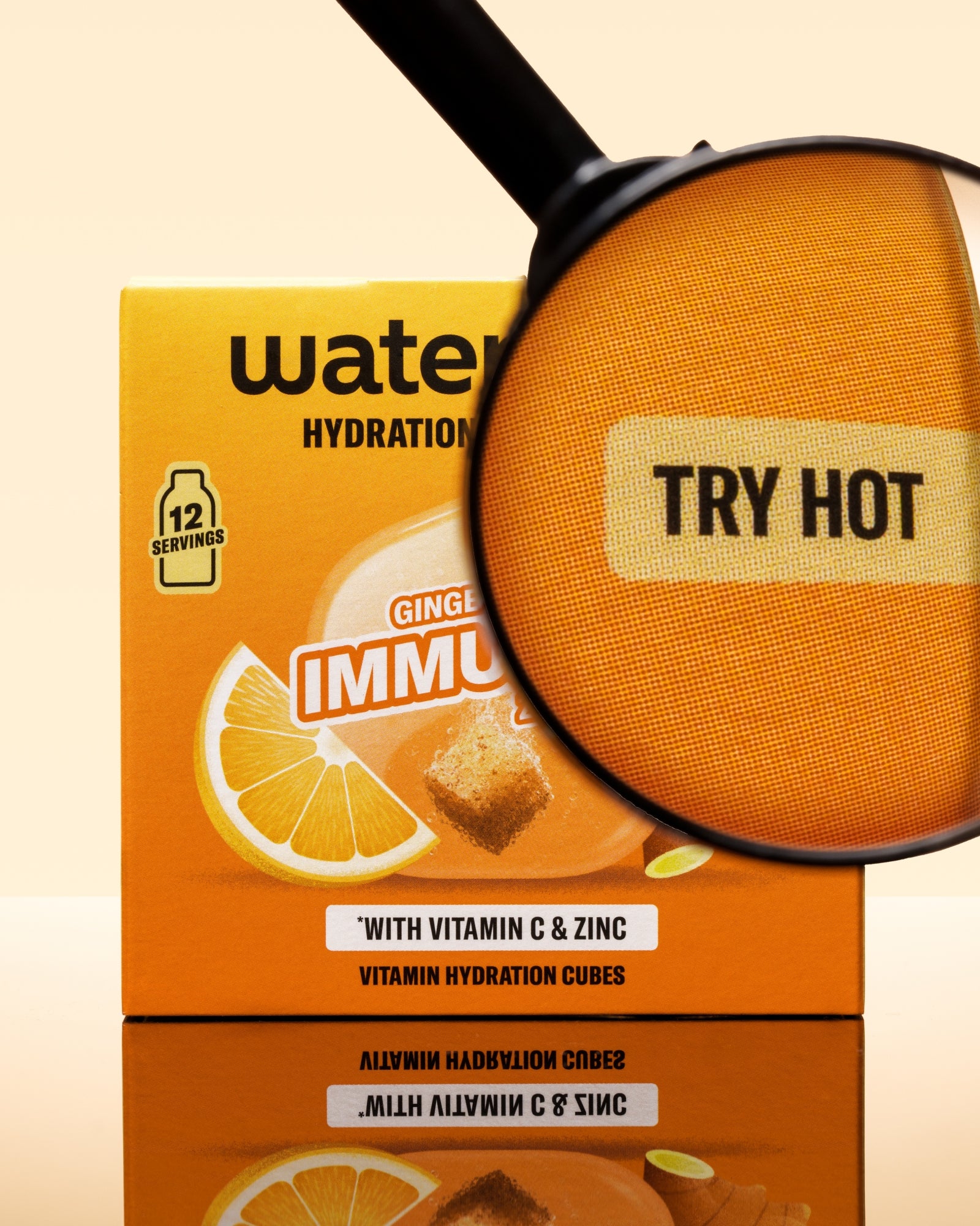 Scatola arancione di cubi di idratazione con immagine di limone e una lente d'ingrandimento sopra la confezione.