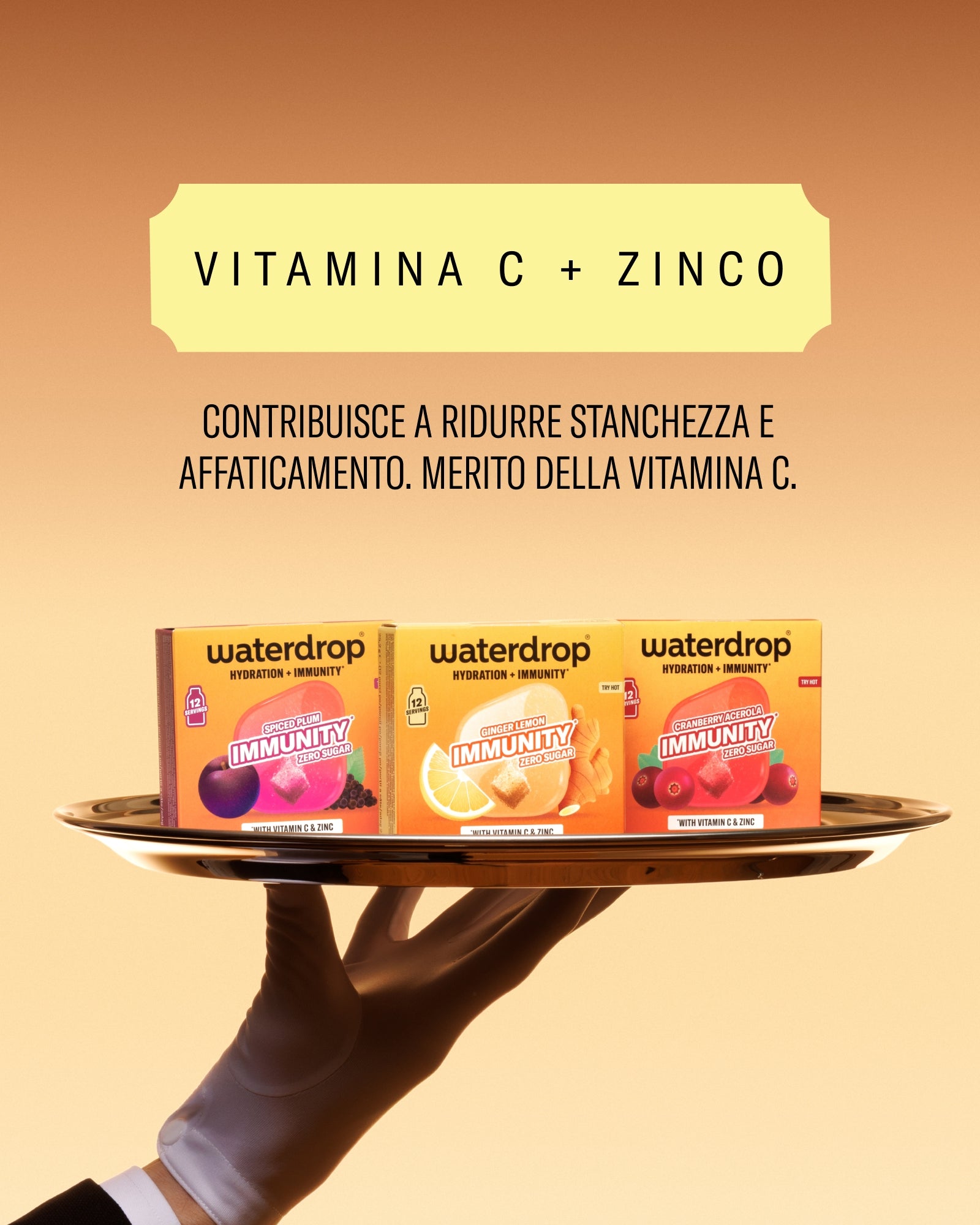 Una mano sostiene un vassoio con tre confezioni Waterdrop di vitamina C + zinco su uno sfondo caldo sfumato.