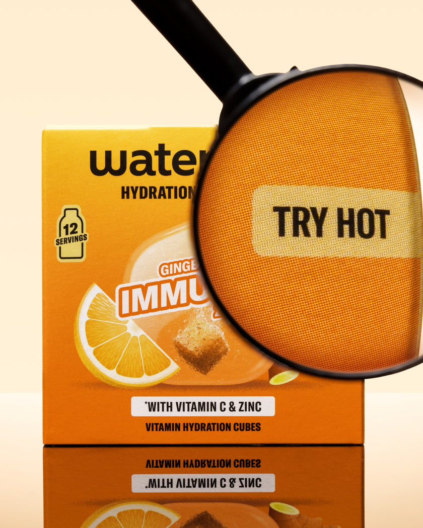 Scatola arancione di cubetti di idratazione con lente di ingrandimento su un cubetto arancione.