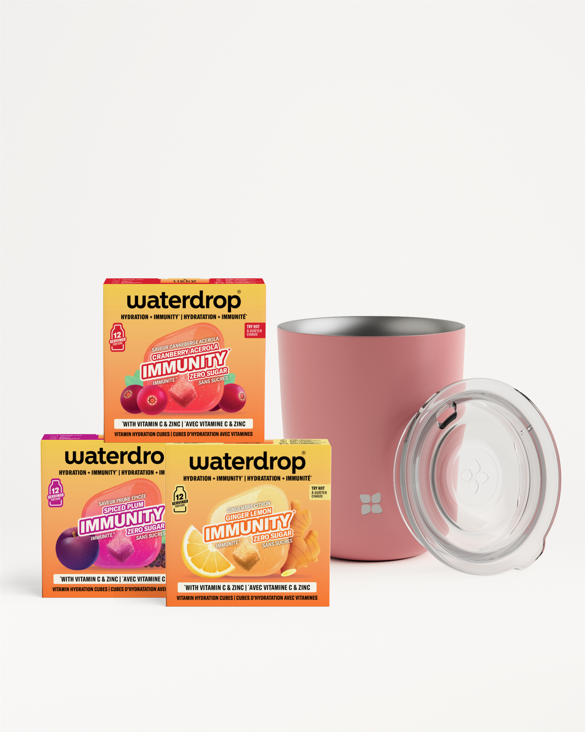 Scatole e confezioni di integratori immunitari accanto a un mug rosa isolante con coperchio trasparente.