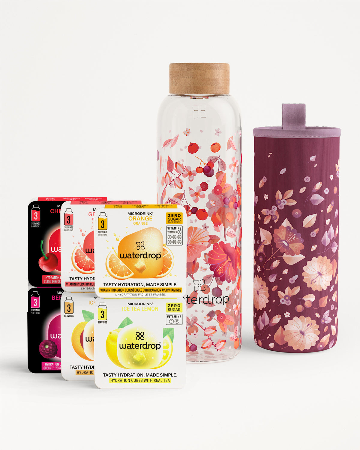 Scatole assortite di pastiglie Waterdrop per gusto con una bottiglia d’acqua in vetro a motivo floreale e una copertura floreale coordinata.