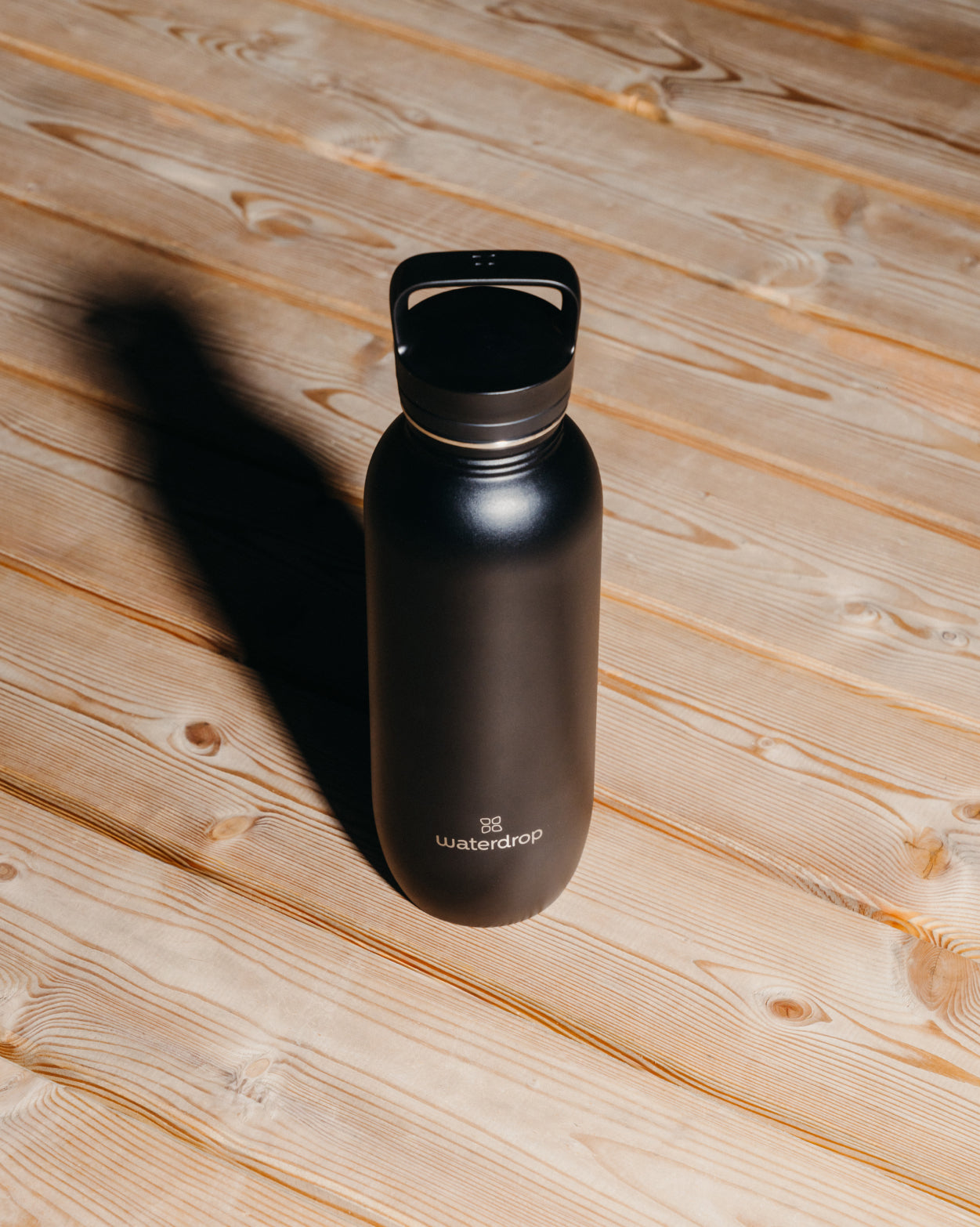 Borraccia Ultraleggera - Coperchio con Cannuccia su superficie di legno.